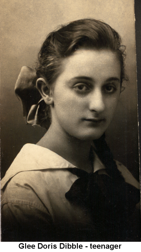 Sepia-tone portrait photo of Glee Doris Dibble, her dark hair pulled back loosely and tied with a dark ribbon, wearing a modified 'sailor' blouse with a large dark ribbon bow in front; unsmiling, eyes slightly to the right.